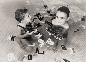 Anonyme. Enfants jouant avec des lettres en bois dans une piscine à Venice. Californie, vers 1930. Photographie. Collection particulière.