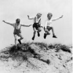 Société. Enfance. Trois garçons sautant dans les dunes. Vers 1955. Photographie. Collection particulière.