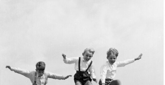 Société. Enfance. Trois garçons sautant dans les dunes. Vers 1955. Photographie. Collection particulière.