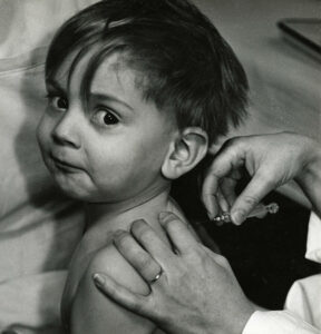 Pottier, Jean. Enfant se faisant vacciner. 1957. Photographie. Collection particulière.